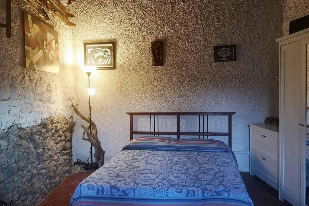um quarto com uma cama e uma parede de pedra em Rifugio delle Querce em Staffoli