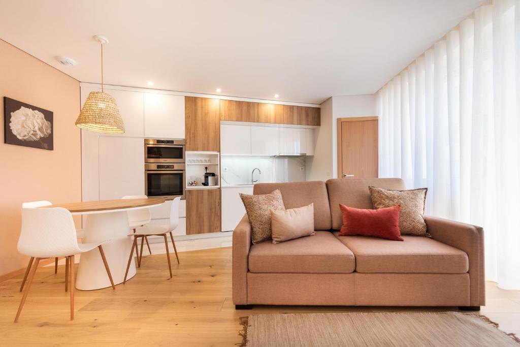 un soggiorno e una cucina con un divano e un tavolo di Casa das Musas 2 a Porto