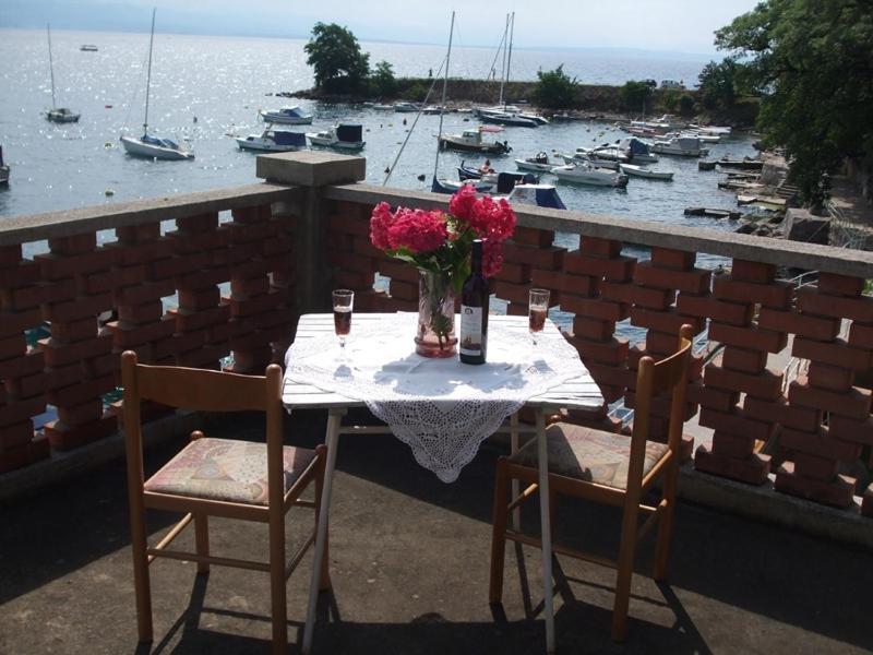 een tafel met een vaas met bloemen op een balkon bij Apartment in Ika with sea view, terrace, air conditioning, WiFi (3699-2) in Ika