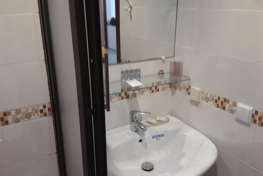 a bathroom with a white sink and a mirror at Magnifique appartement a louer à fnideq avec parking gratuit in Fnidek
