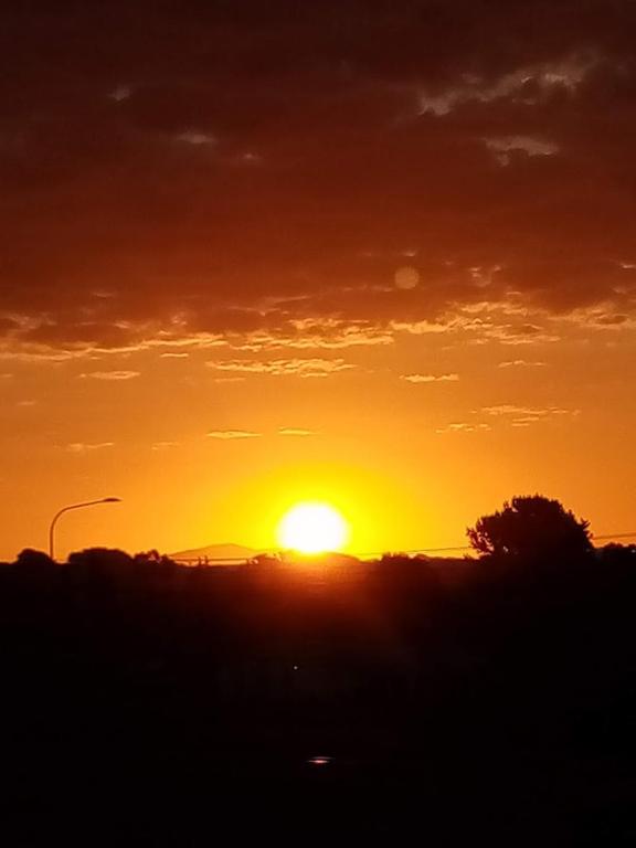 a sunset with the sun setting in the sky at Manakau House The Old Manakau Hotel 1920 in Manakau
