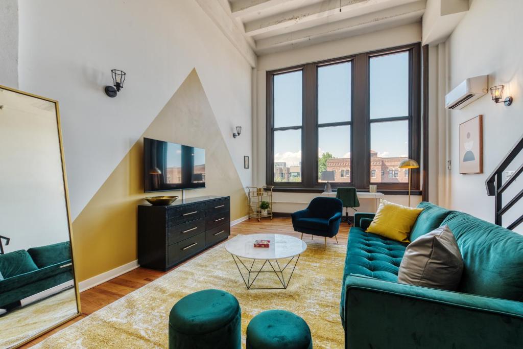 a living room with a couch and a tv at Sosuite at West Lofts - West Philadelphia in Philadelphia