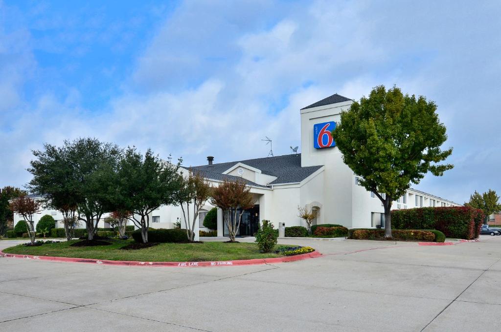 a large white building with a sign on it at Motel 6-Plano, TX - West - Frisco in Plano