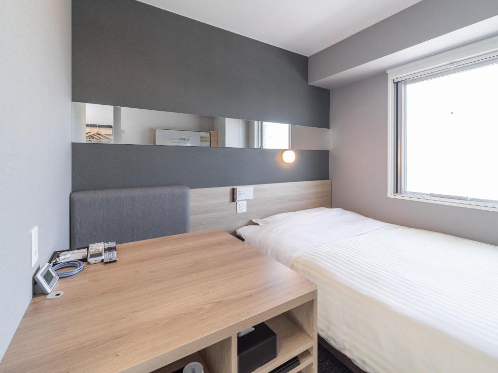 Postel nebo postele na pokoji v ubytování Super Hotel Nagoya Shinkansenguchi