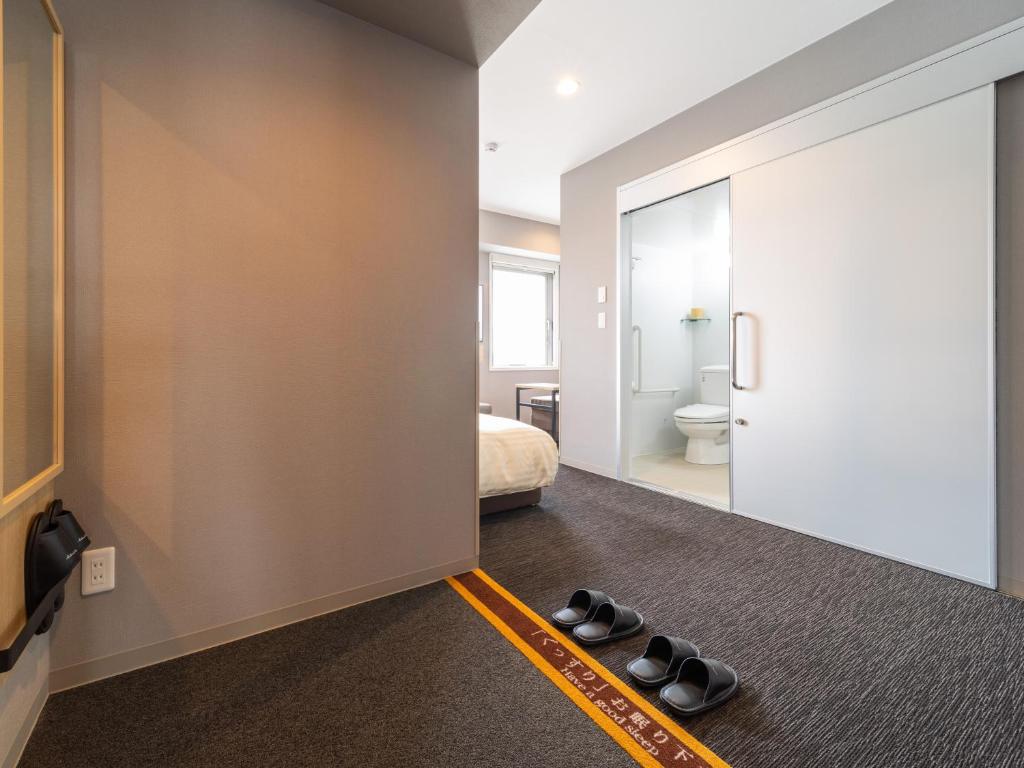 Postel nebo postele na pokoji v ubytování Super Hotel Nagoya Shinkansenguchi