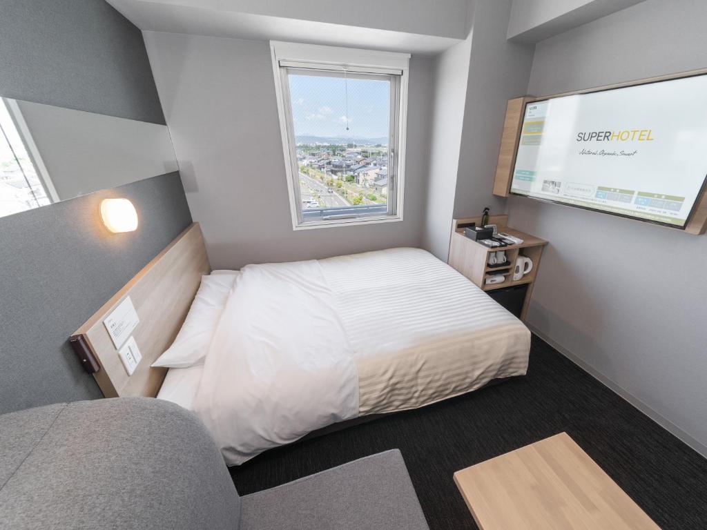 Postel nebo postele na pokoji v ubytování Super Hotel Nagoya Shinkansenguchi