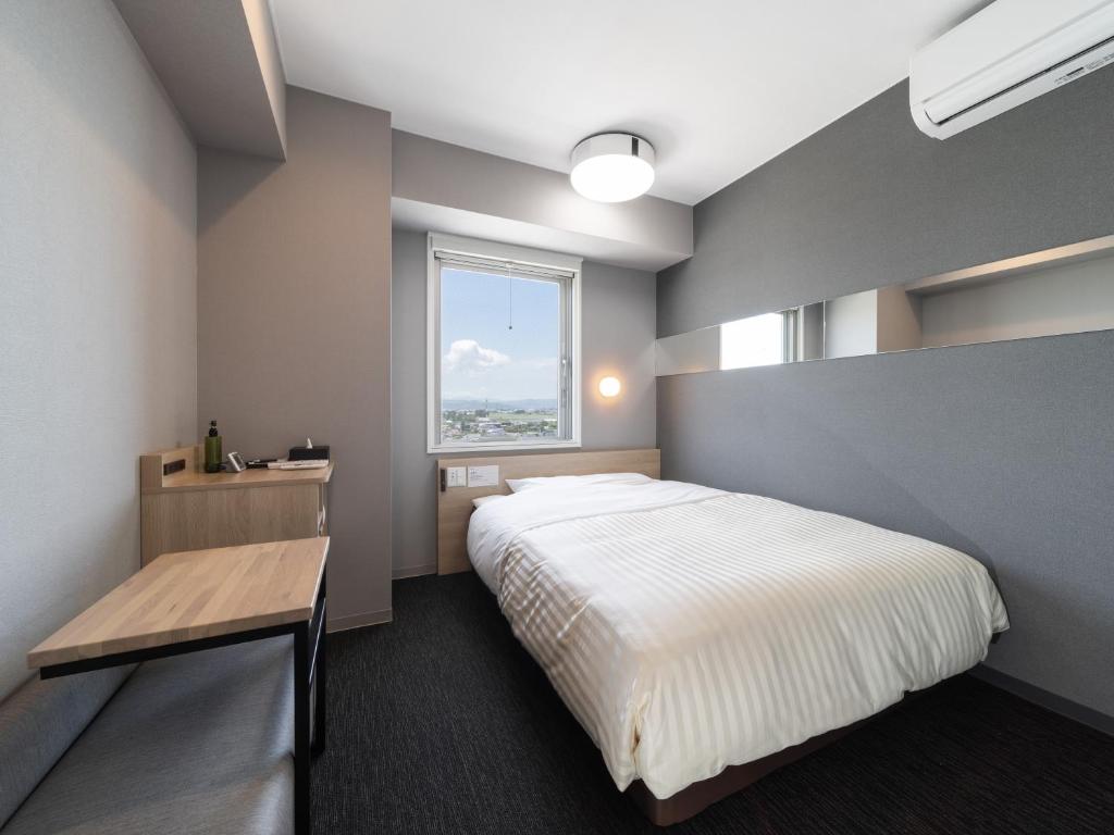 Postel nebo postele na pokoji v ubytování Super Hotel Nagoya Shinkansenguchi
