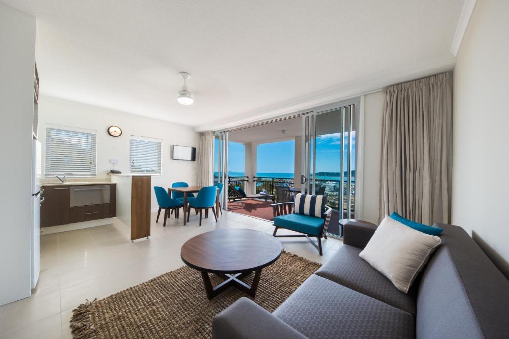 a living room with a couch and a table at The Sebel Whitsundays in Airlie Beach