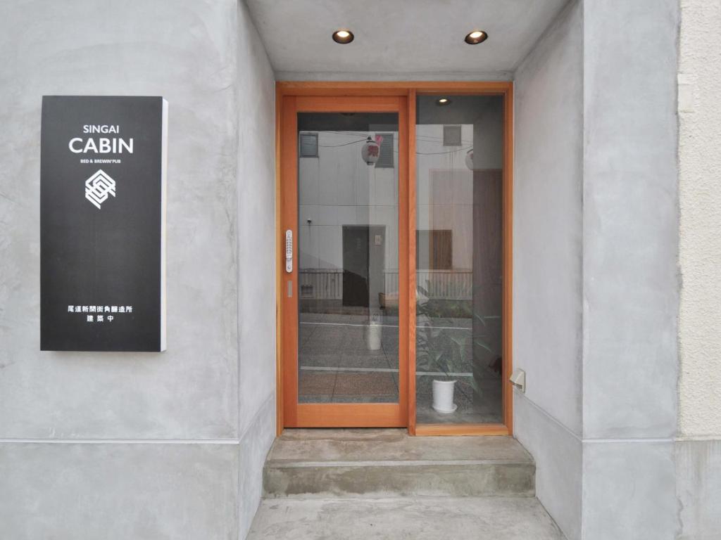 una porta a vetri di un edificio con un cartello sopra di SINGAI CABIN a Onomichi