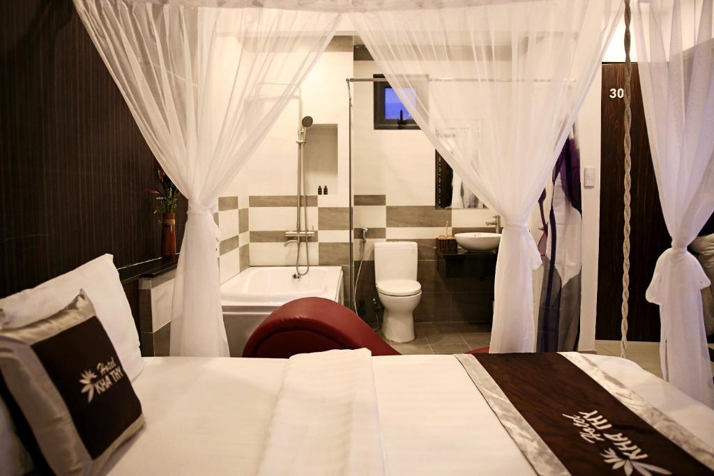 a bedroom with a bed and a tub and a toilet at Kha Thy Hotel in Ho Chi Minh City