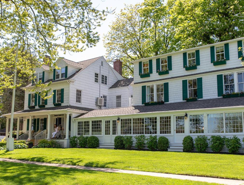 a large white house with green shutters at The Maidstone Hotel in East Hampton