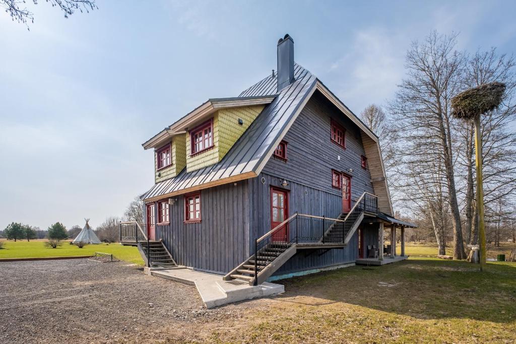 een huis met een gambrel dak en een trap erop bij Soomaa Puhkeküla in Riisa