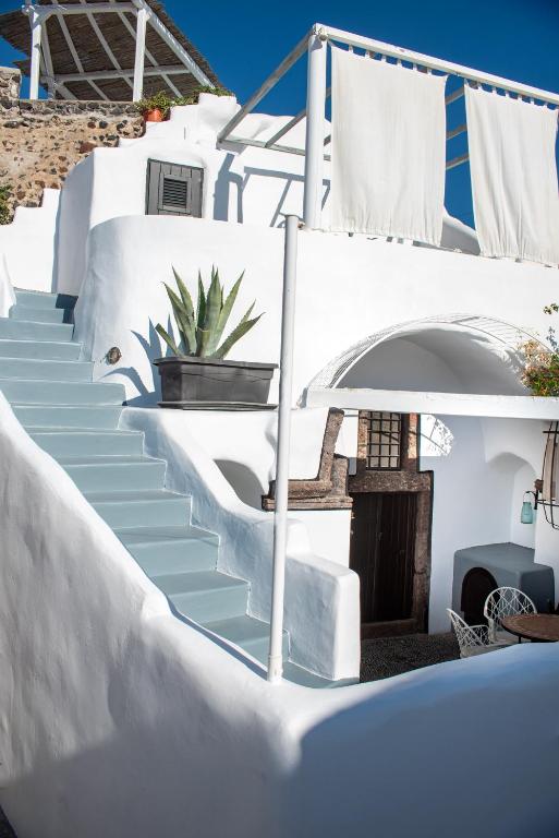 a staircase leading up to a house with a potted plant at Villa Orpheus Santorini in Megalokhori