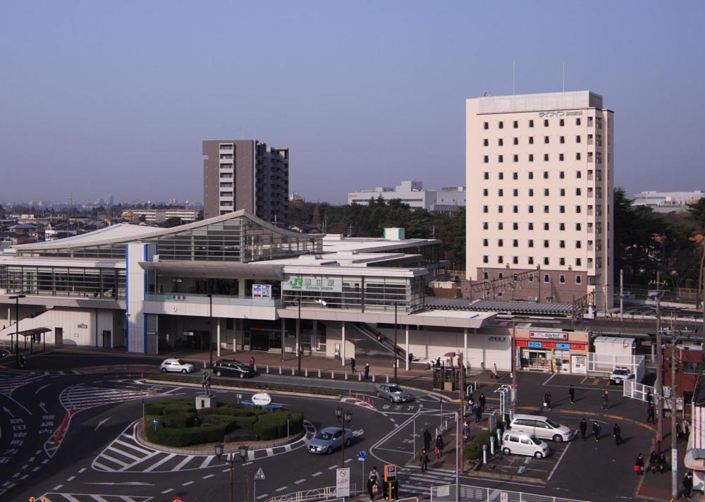 a city with a building and a street with cars at Life Inn Katsuta Station West in Hitachinaka