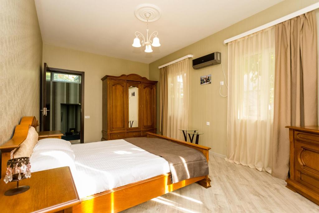 a bedroom with a bed and a dresser and a window at Rustaveli Two Bedroom Apartment with 5 Star Location in Tbilisi City