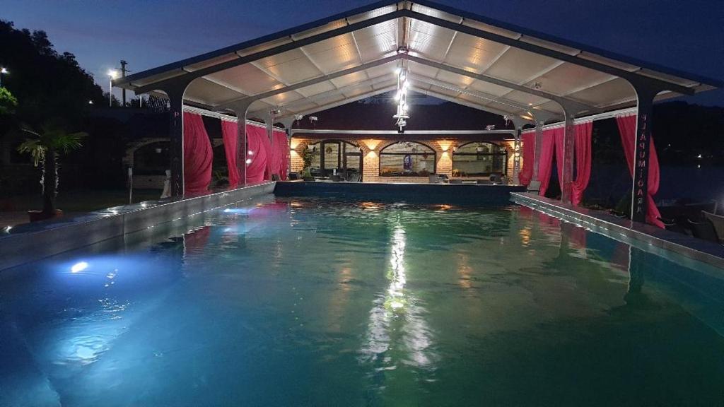 an indoor swimming pool at night with a building at Cabana Plapumioara in Eşelniţa