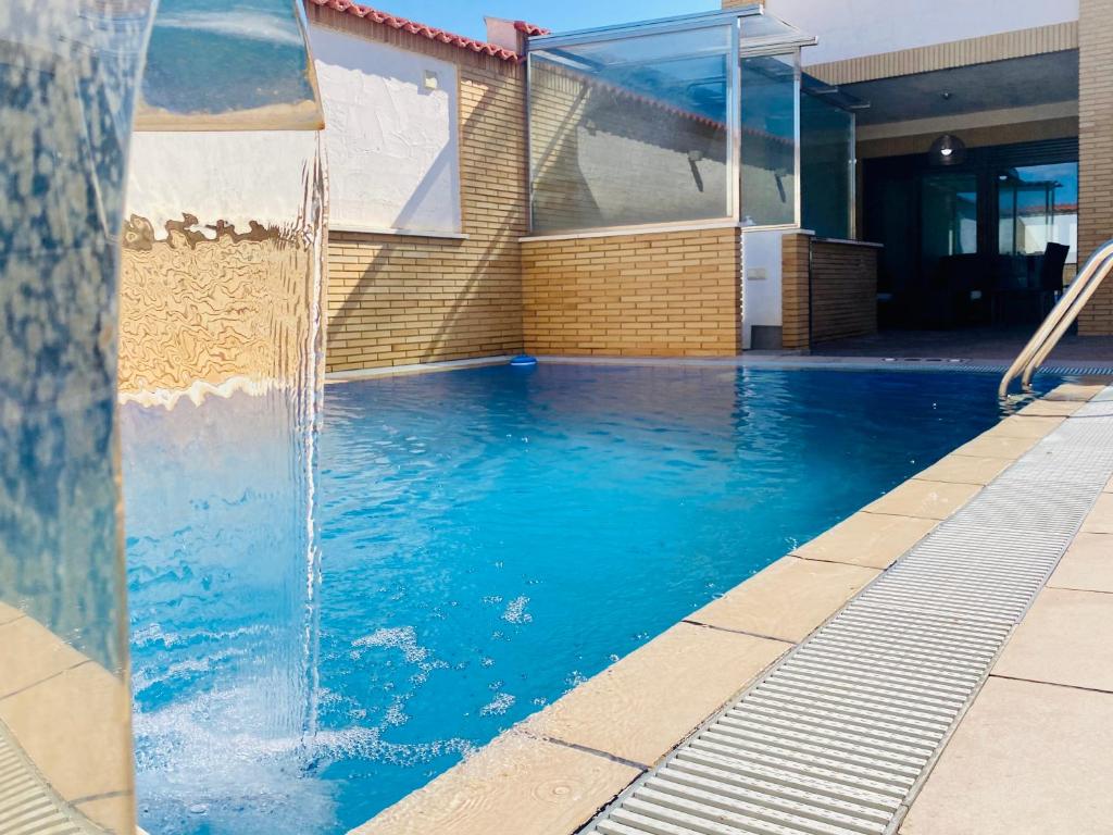 una piscina con una fuente de agua frente a un edificio en La choza de Nolasco, en Valdeganga