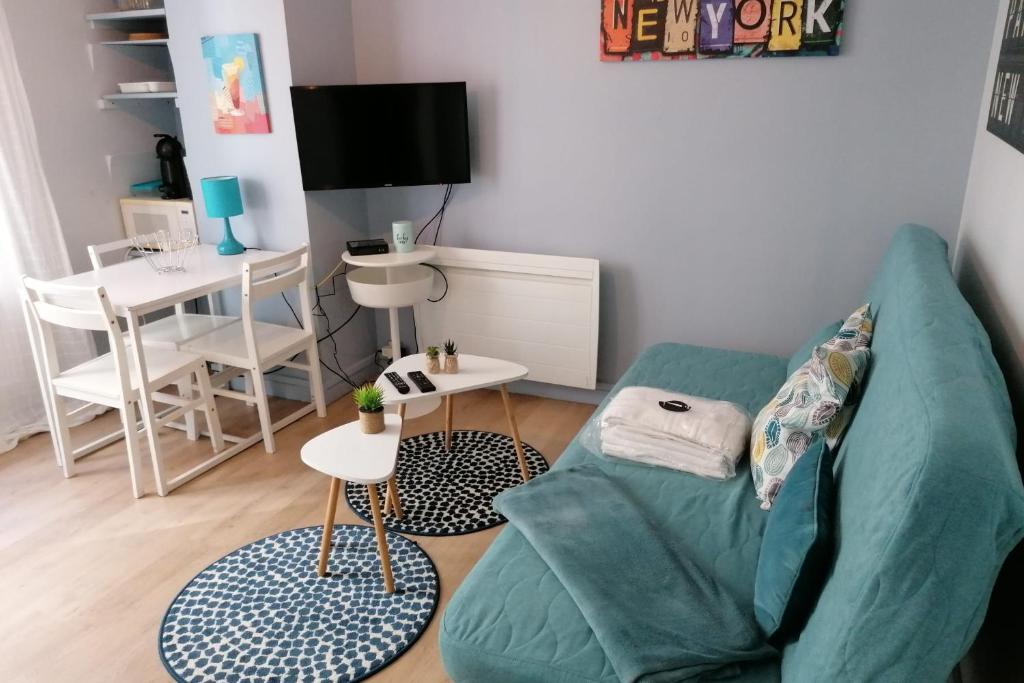 un salon avec un canapé vert et une table dans l'établissement #J7 The Maginot Caserne de Bonne, à Grenoble