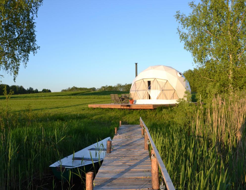 une promenade menant à une tente en forme de dôme dans un champ dans l'établissement Glempings Velo Latgale, à Izvalta