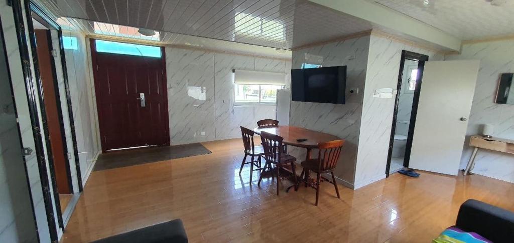 uma sala de jantar com uma mesa e cadeiras e uma televisão em Bellhaven Park em Heatherbrae