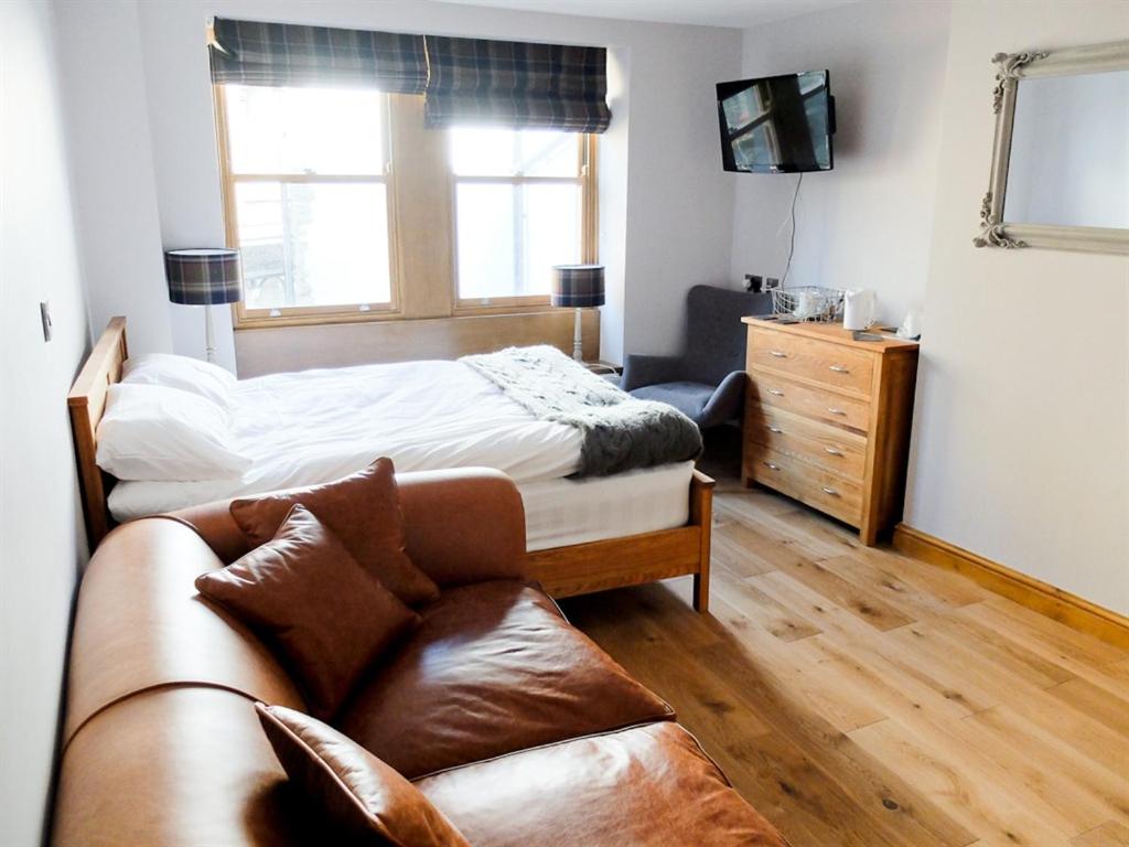 uma sala de estar com uma cama e um sofá em Rooms at The Nook em Holmfirth