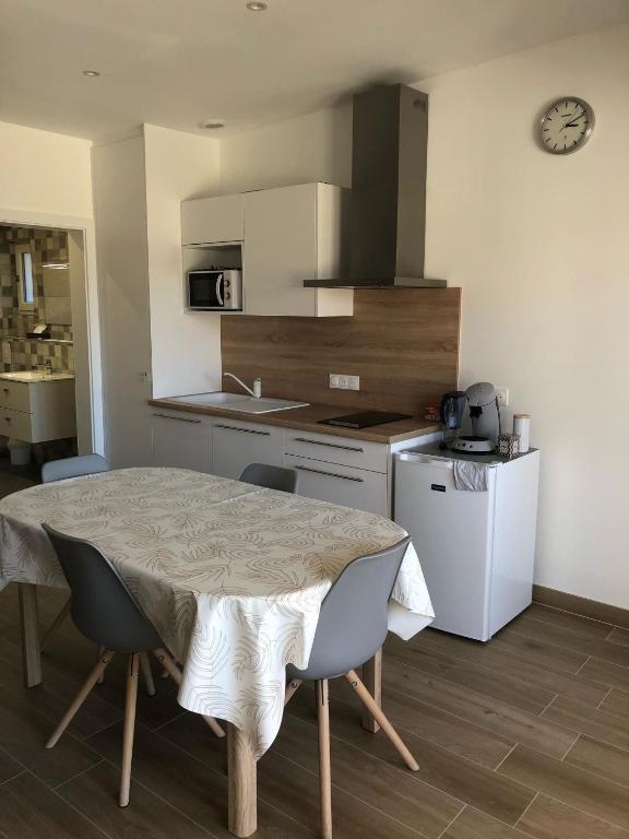 a kitchen with a table and chairs and a kitchen with a stove at Sollaris Appartement 1ère étage à 11km de Europa-Park in Friesenheim
