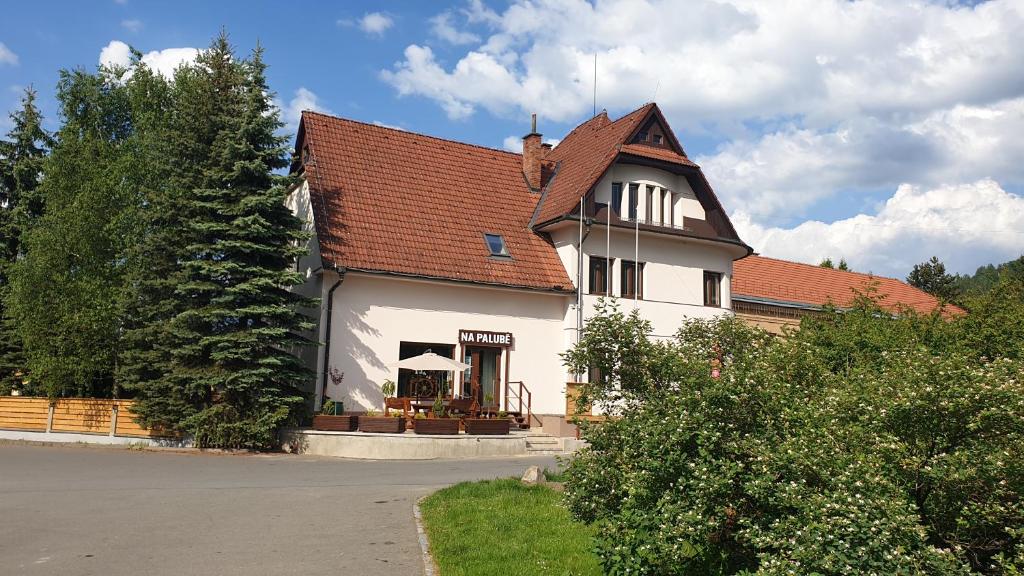 een groot wit huis met een rood dak bij Pension Fortuna in Halenkov