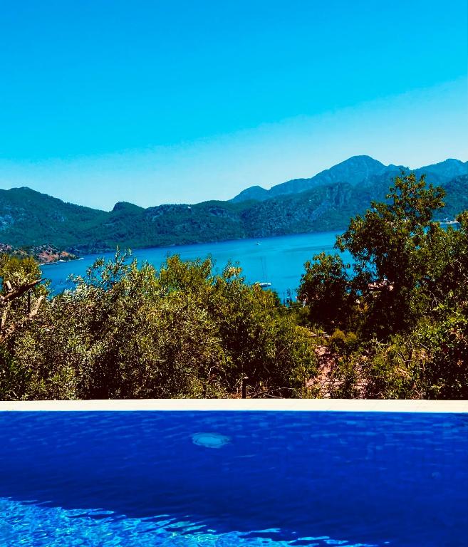 two pictures of a lake with mountains in the background at Defne Residence Selimiye in Marmaris
