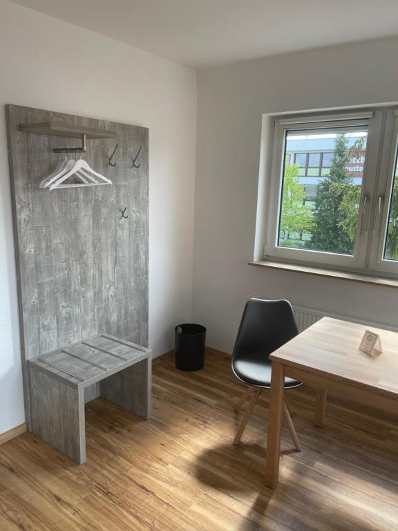 Zimmer mit einem Schreibtisch, einem Tisch und einem Stuhl in der Unterkunft Boardinghouse-Heuchelhof in Würzburg
