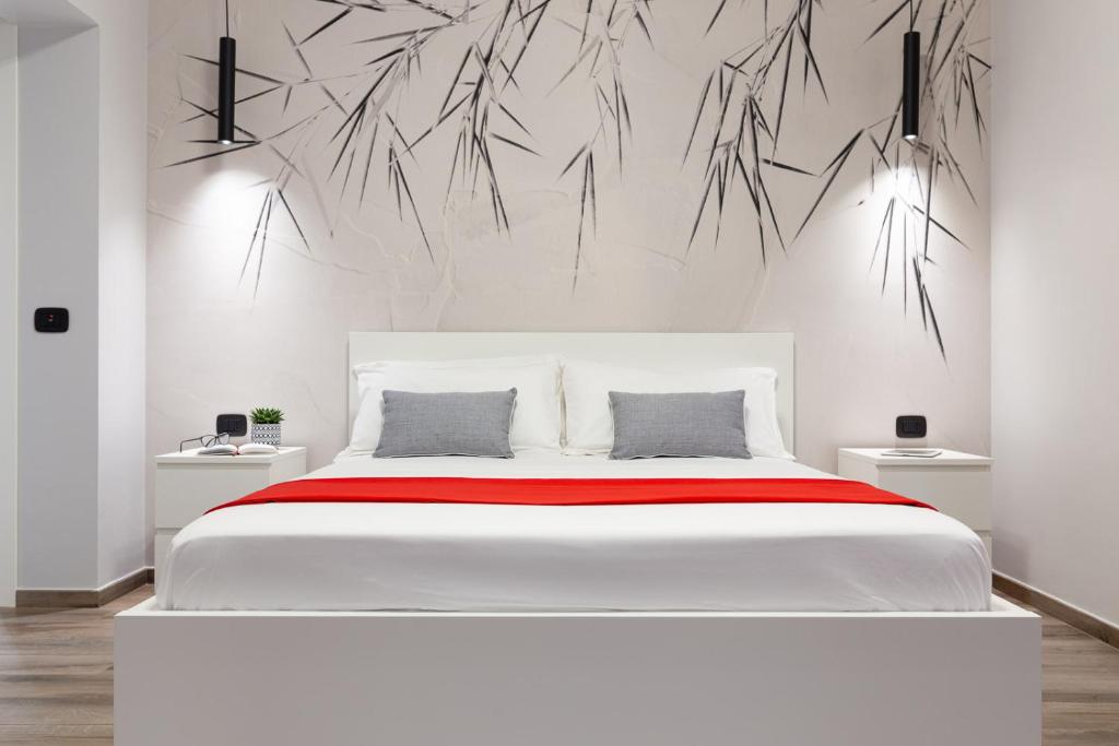 ein Schlafzimmer mit einem großen weißen Bett mit einem Gemälde an der Wand in der Unterkunft A CASA DEI NONNI in Gaeta