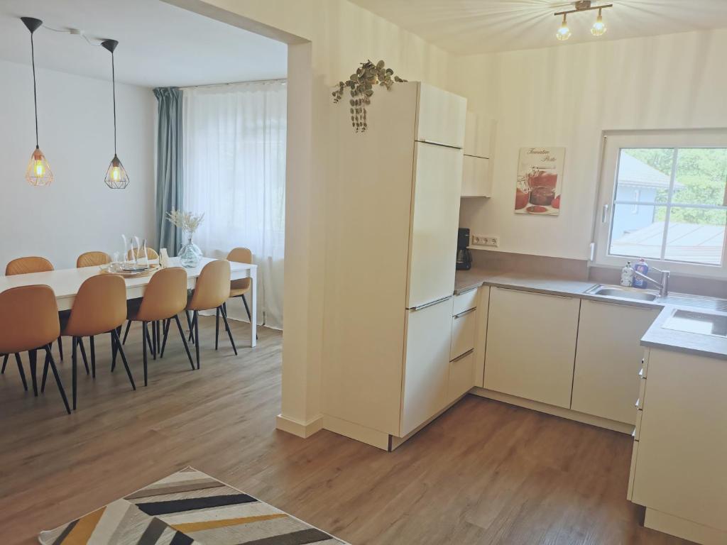 una cucina e una sala da pranzo con tavolo e frigorifero di Ferienhaus Theodor OG a Laufen