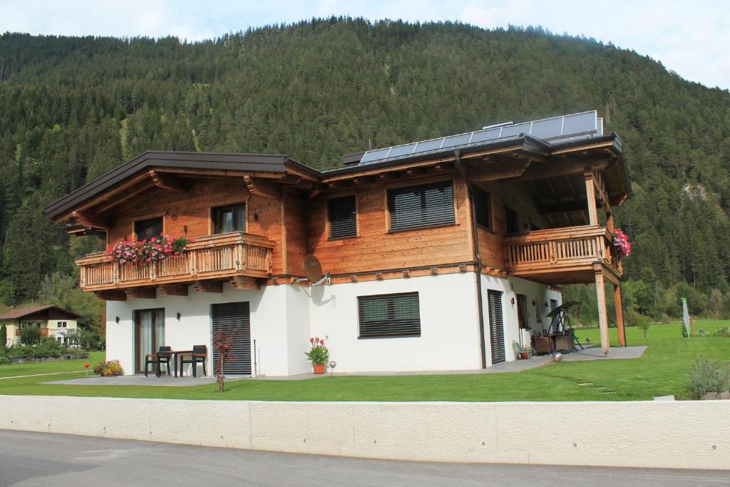 a large wooden house with a balcony on top of it at Villa Alpin in Holzgau