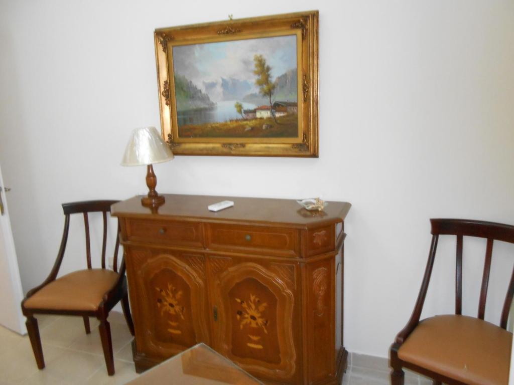 un cuadro colgado en una pared con dos sillas en Elena's old Corfu town apartment, en Corfú