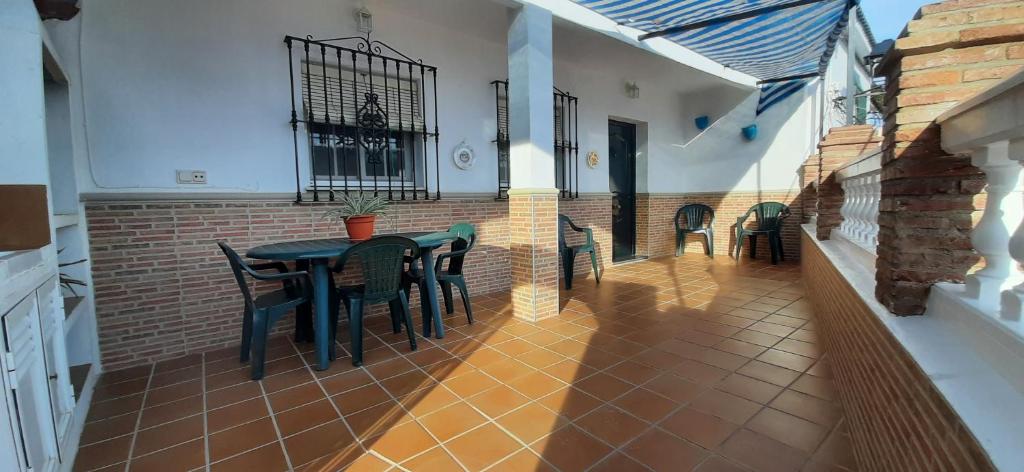eine Terrasse mit einem Tisch und Stühlen in einem Gebäude in der Unterkunft Moclinejo House in Málaga