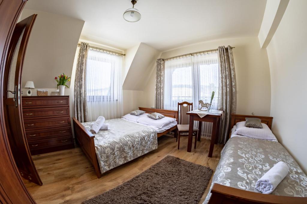 a bedroom with two beds and a mirror at Gościniec Polana Błociska-Na Błociskach in Małe Ciche
