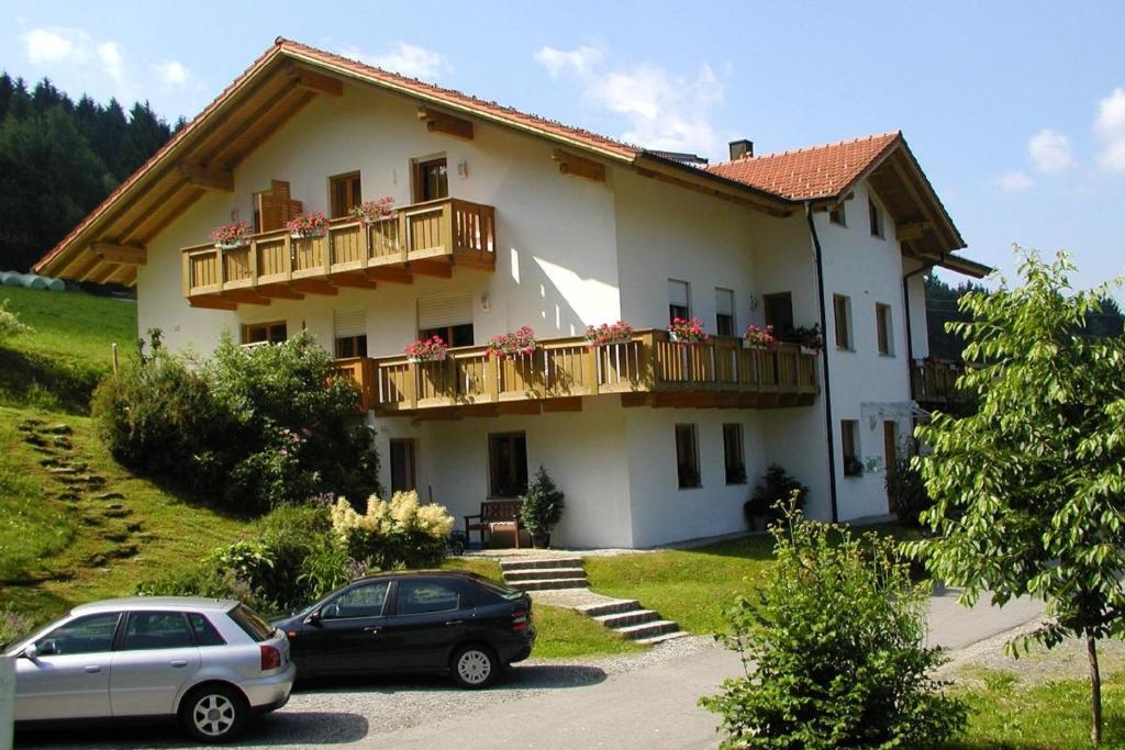 a house with two cars parked in front of it at Apartmenthaus Fürstenzeche in Lam