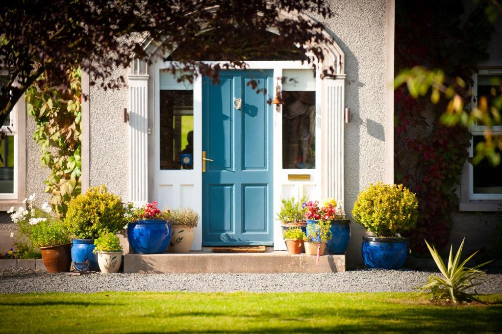 une porte bleue avec des plantes en pot devant une maison dans l'établissement Lynster House, à Monaghan