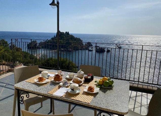 una mesa con comida y vistas al océano en SUITE ISOLA BELLA, en Taormina