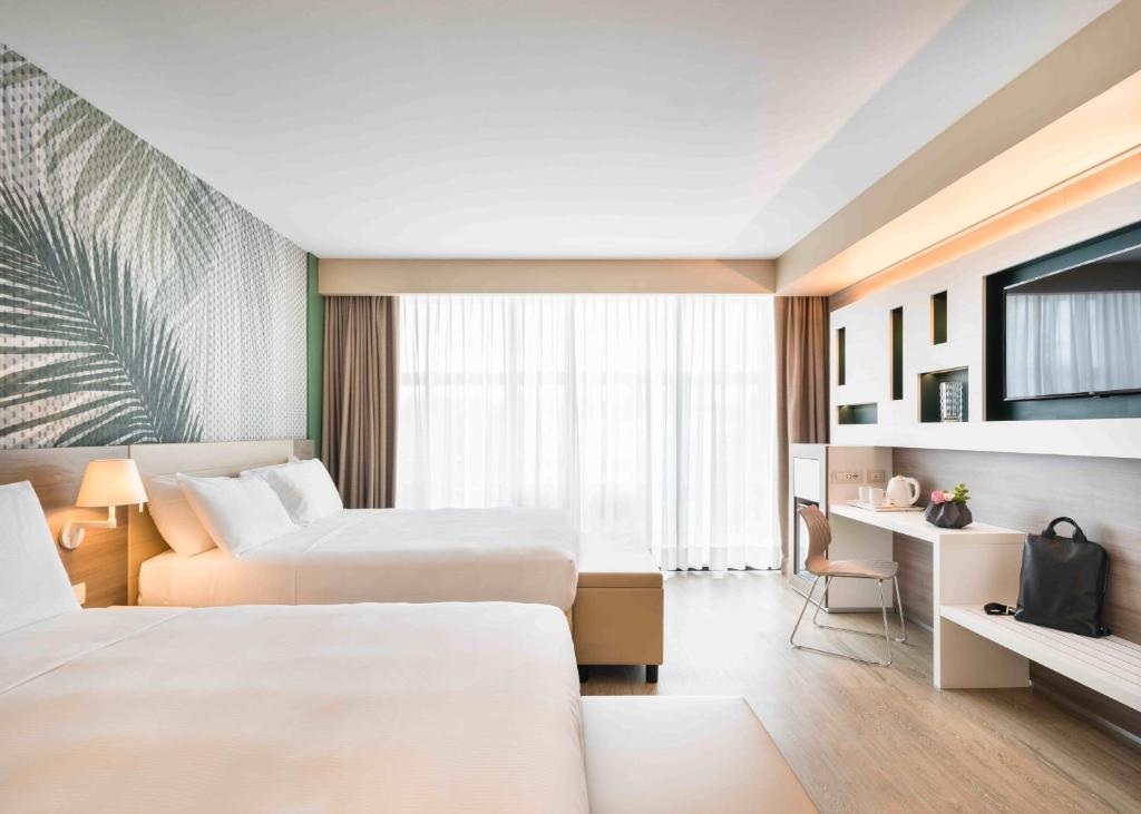 a hotel room with two beds and a tv at Enjoy Garda Hotel in Peschiera del Garda