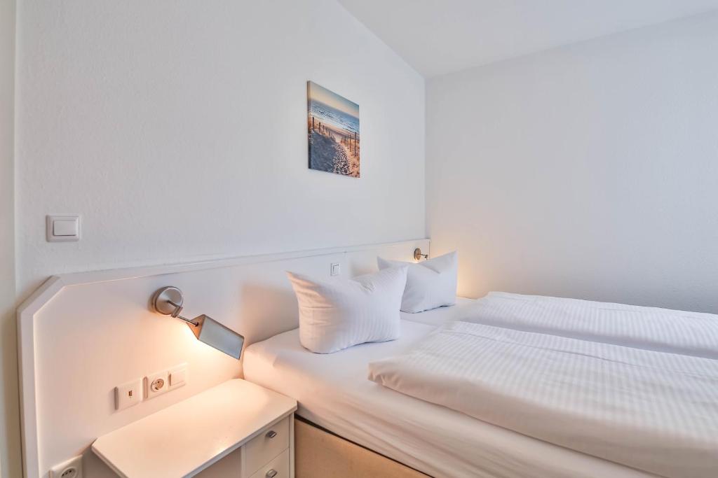 - une chambre blanche avec un lit et une lampe dans l'établissement FEWO Ava - im Sommer ist ein Strandkorb inclusive, à Zempin
