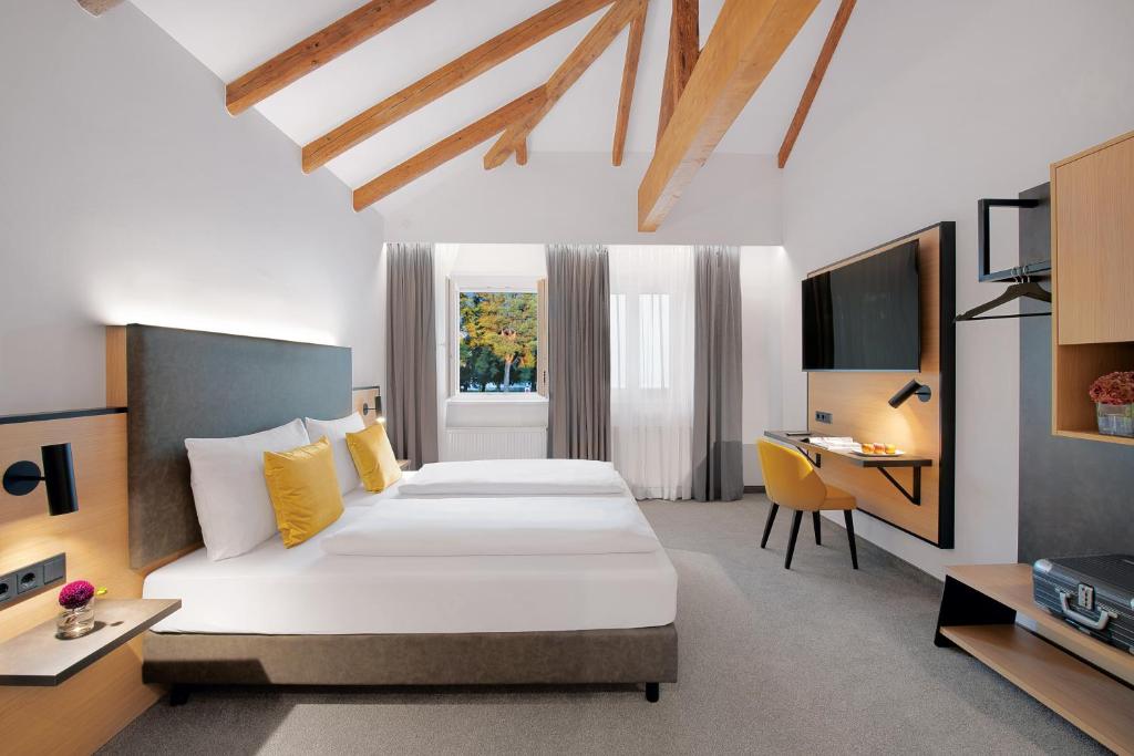 Un pat sau paturi într-o cameră la Stadthotel Oberndorf - 24h Self Check-In Terminal