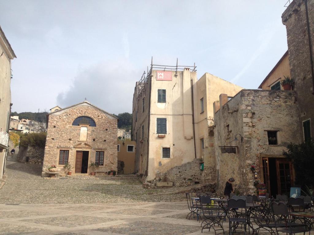 grupa kamiennych budynków ze stołami i krzesłami w obiekcie Casa del mare Ligure Borgio Verezzi w mieście Borgio Verezzi