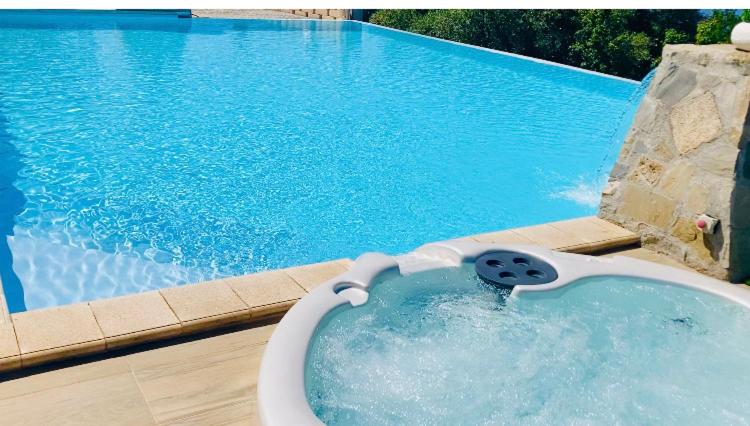 a bath tub in front of a swimming pool at Green Park Hotel & Residence in Bagnara Calabra