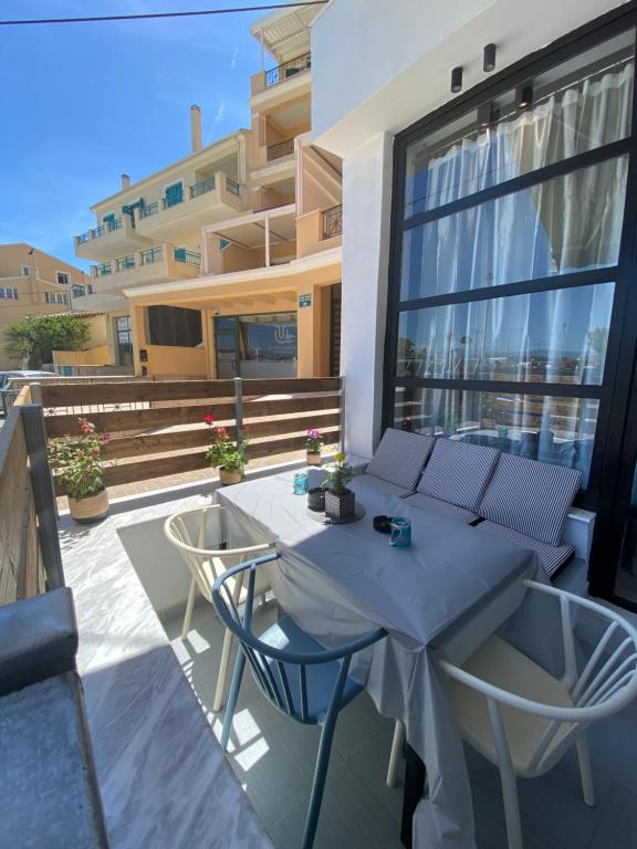 a patio with a table and chairs on a balcony at Corfu port apartment in Mantoúkion