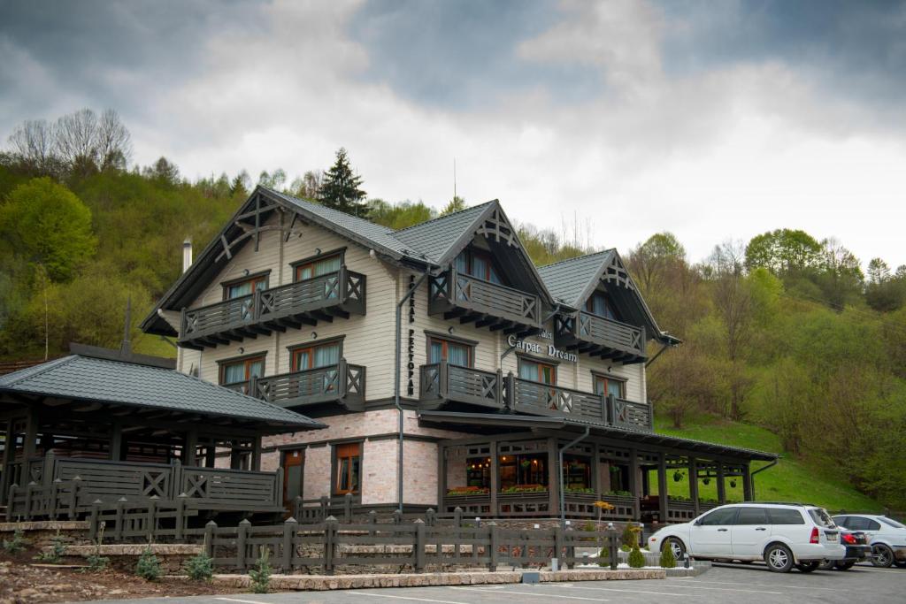 a large wooden house with a car parked in front of it at Chalet Carpat Dream in Synevyr