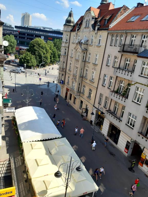 Ein Bus steht in einer Straße mit Gebäuden. in der Unterkunft Apartamenty Katowice Stawowa 5 in Kattowitz