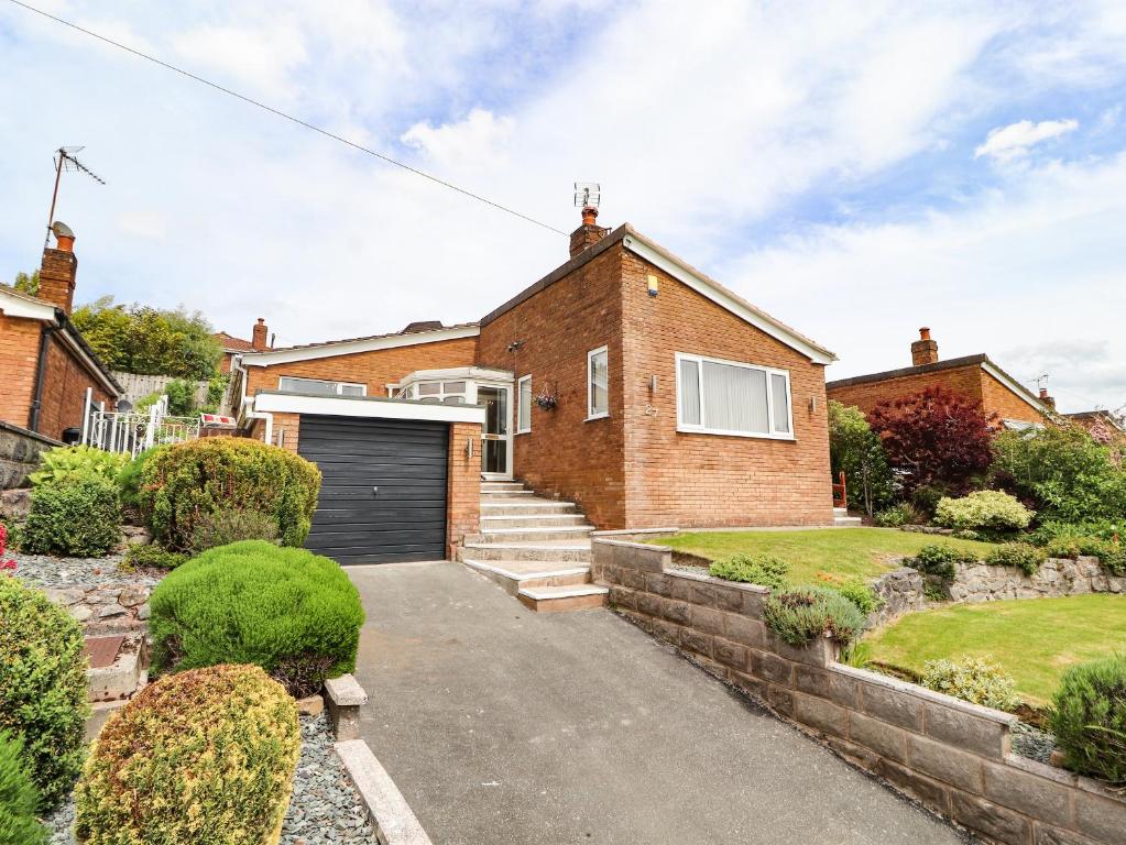 a brick house with a garage at Rose Hill in Holywell