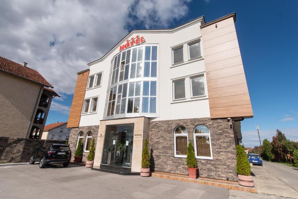 un edificio blanco con un letrero rojo. en Hotel Stari Krovovi, en Novi Sad