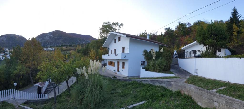 una casa blanca en una colina con una valla en Villa Bianca, en Villa Celiera