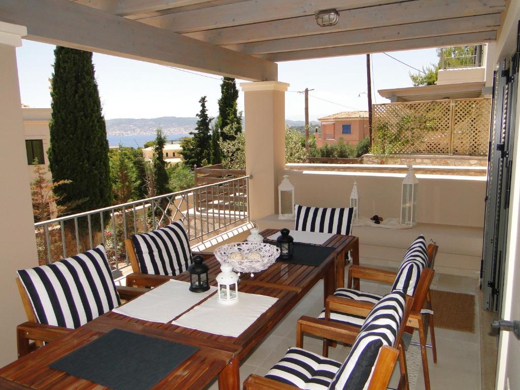 a patio with a table and chairs on a balcony at Porto Heli Villas & Studios in Porto Heli